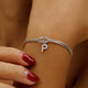 Bracciale intrecciato con zirconi lettera P in rame dorato su polso femminile myemotiojewels
