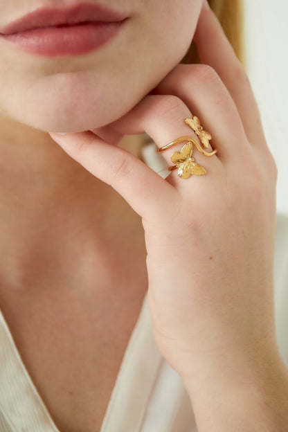 Dettaglio anello donna a forma di farfalla in acciaio dorato indossato, stile botanico
